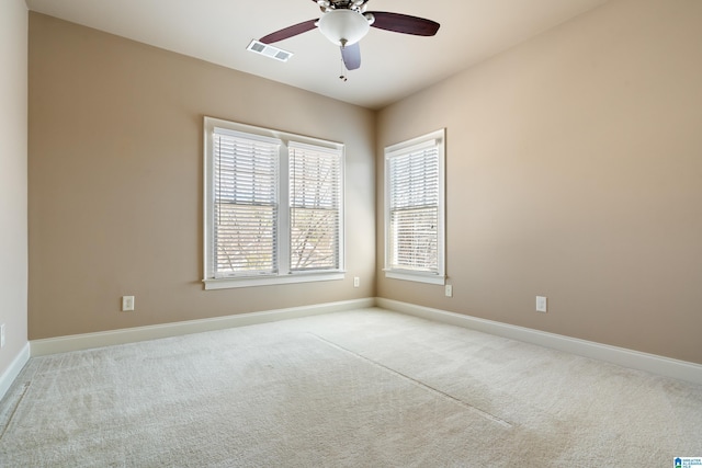 unfurnished room with ceiling fan, baseboards, visible vents, and light carpet