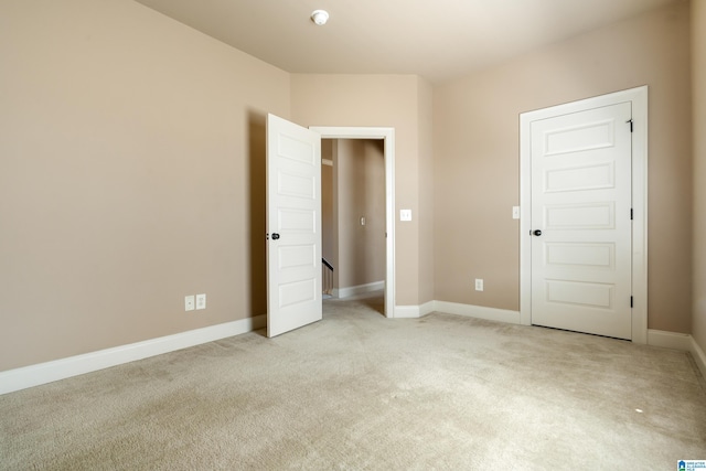 unfurnished bedroom with baseboards and light colored carpet