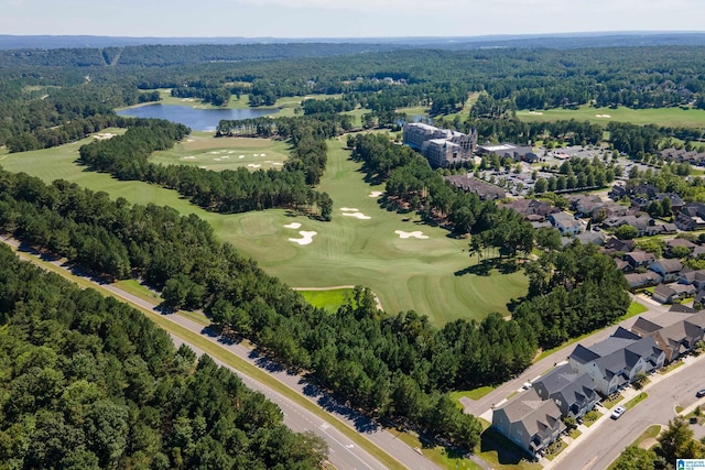 drone / aerial view featuring a forest view, a water view, and golf course view