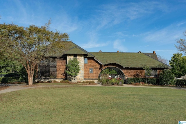 view of front of property featuring stone siding and a front yard