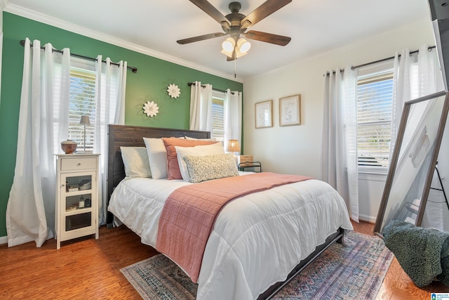 bedroom featuring baseboards, wood finished floors, a ceiling fan, and ornamental molding