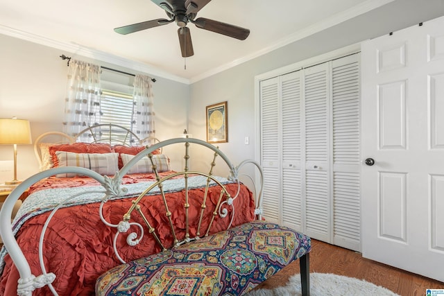 bedroom with a closet, wood finished floors, ceiling fan, and ornamental molding