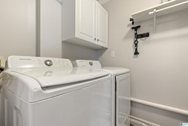 clothes washing area featuring cabinet space and independent washer and dryer