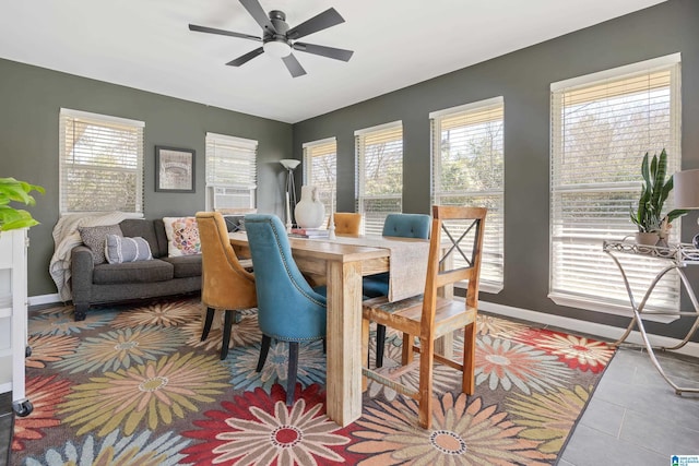 tiled dining area with ceiling fan, cooling unit, and baseboards