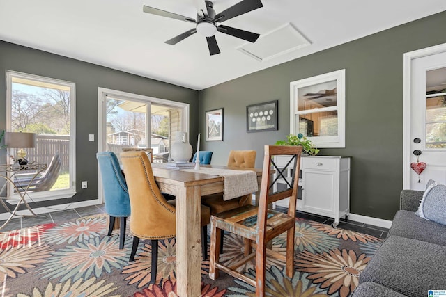 dining room featuring dark tile patterned floors, attic access, and baseboards