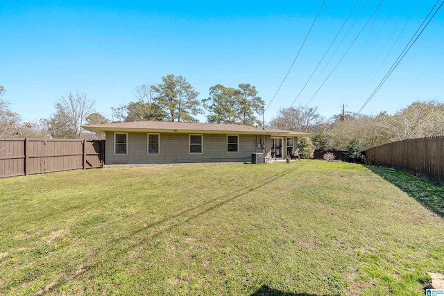 rear view of house featuring a yard, cooling unit, and a fenced backyard