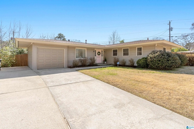 single story home featuring concrete driveway, fence, a garage, and a front yard