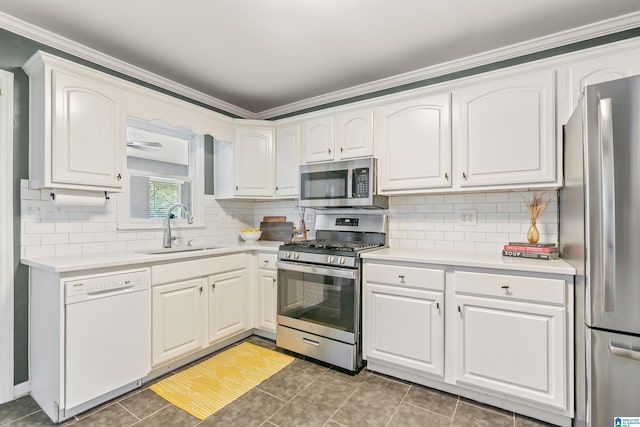 kitchen with a sink, backsplash, appliances with stainless steel finishes, and light countertops