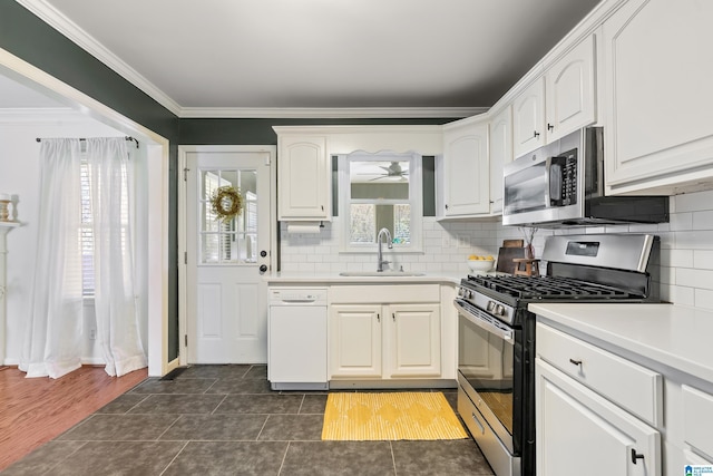 kitchen featuring a sink, appliances with stainless steel finishes, white cabinets, and crown molding