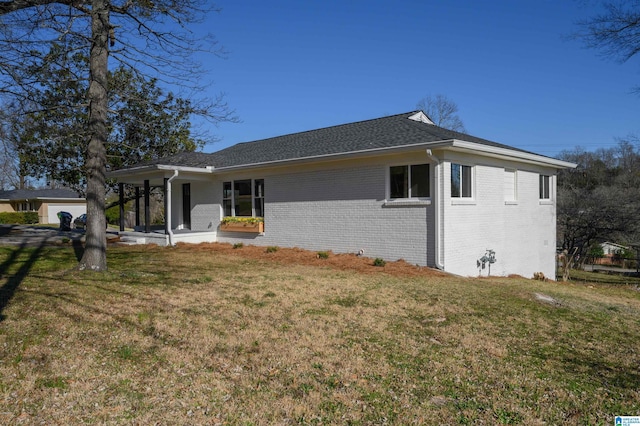 exterior space with brick siding and a front yard