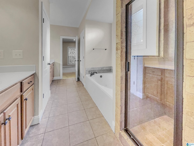 bathroom featuring tile patterned floors, a stall shower, vanity, and a garden tub