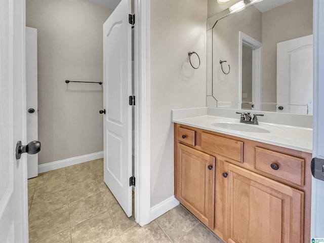 bathroom featuring vanity, baseboards, and tile patterned flooring