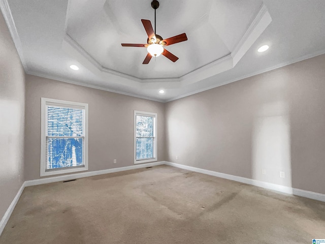 unfurnished room featuring a tray ceiling, crown molding, and baseboards