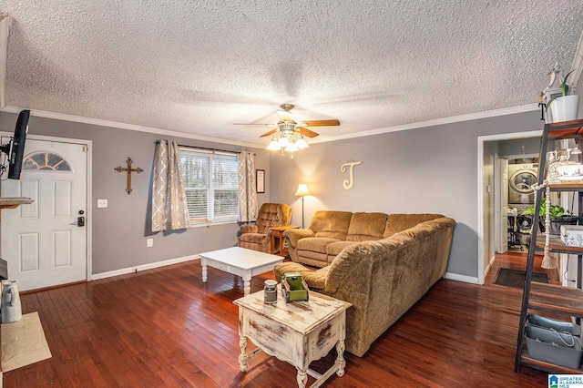 living area with a ceiling fan, baseboards, stacked washing maching and dryer, hardwood / wood-style floors, and crown molding