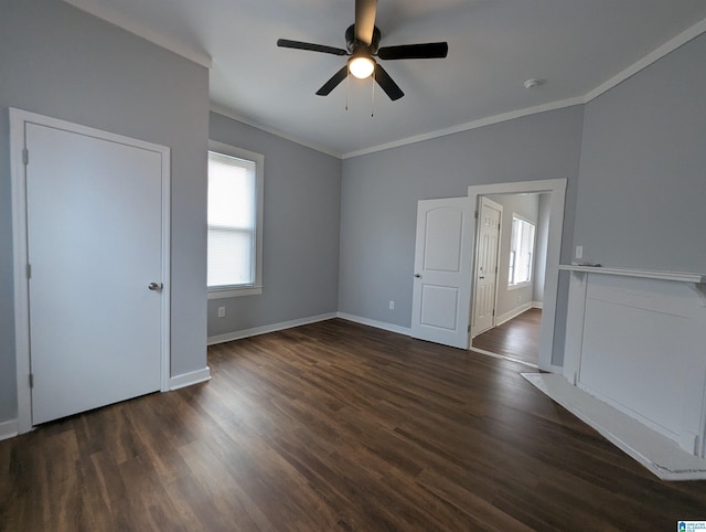 spare room featuring dark wood-style floors, ceiling fan, baseboards, and crown molding