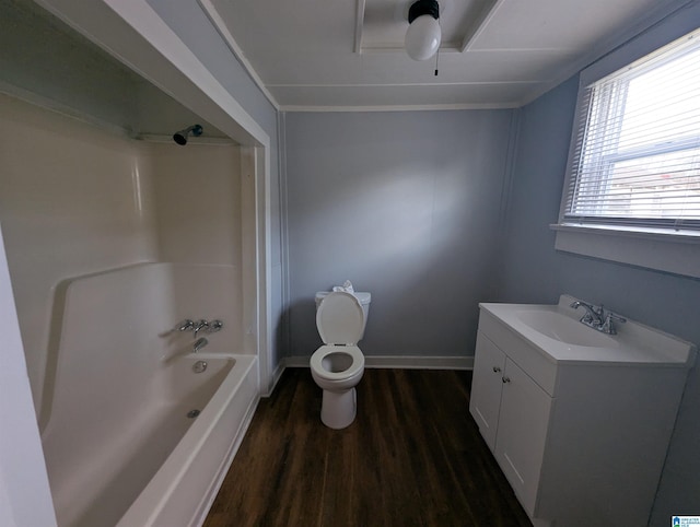 bathroom featuring baseboards, toilet, wood finished floors,  shower combination, and vanity