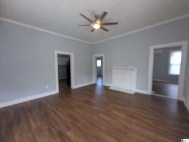 unfurnished living room featuring ornamental molding, dark wood finished floors, a ceiling fan, and baseboards