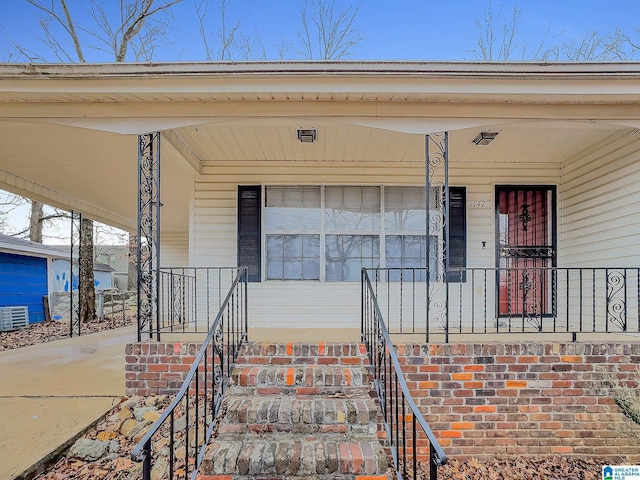 view of exterior entry featuring covered porch