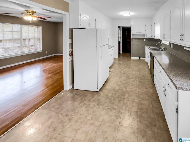 kitchen with dishwasher, white cabinetry, a sink, and freestanding refrigerator