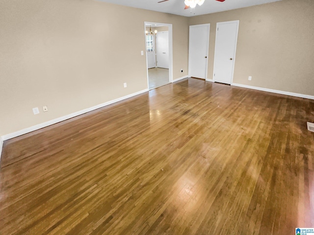 interior space with a ceiling fan, visible vents, baseboards, and wood finished floors