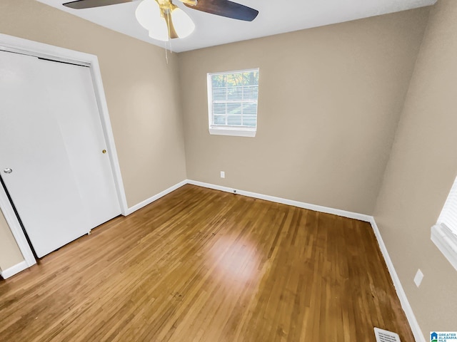 unfurnished bedroom with wood finished floors, visible vents, and baseboards