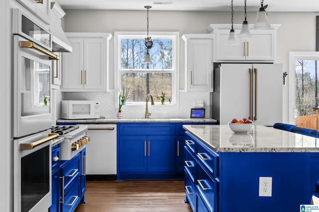 kitchen with white appliances, blue cabinetry, dark wood-style flooring, and white cabinets