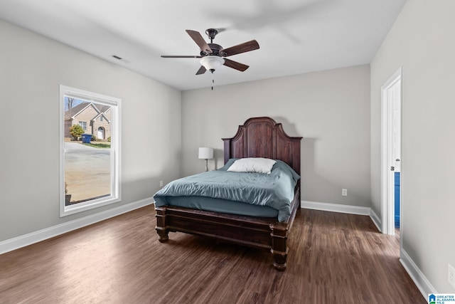 bedroom with ceiling fan, dark wood-type flooring, and baseboards