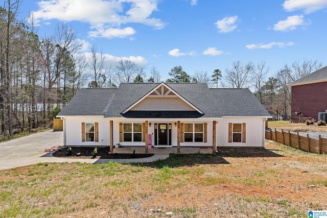 modern farmhouse featuring fence, driveway, and roof with shingles