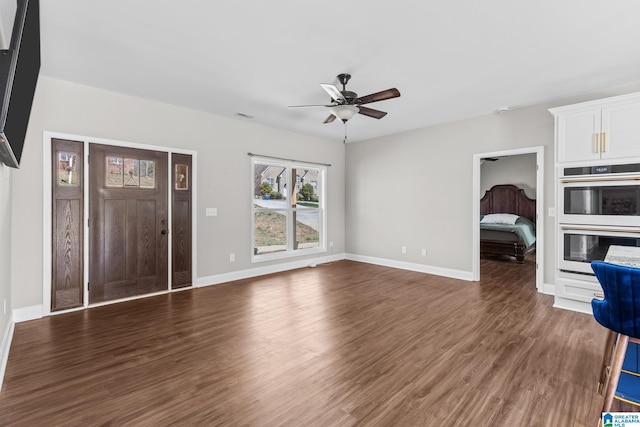 unfurnished living room with baseboards, wood finished floors, visible vents, and ceiling fan