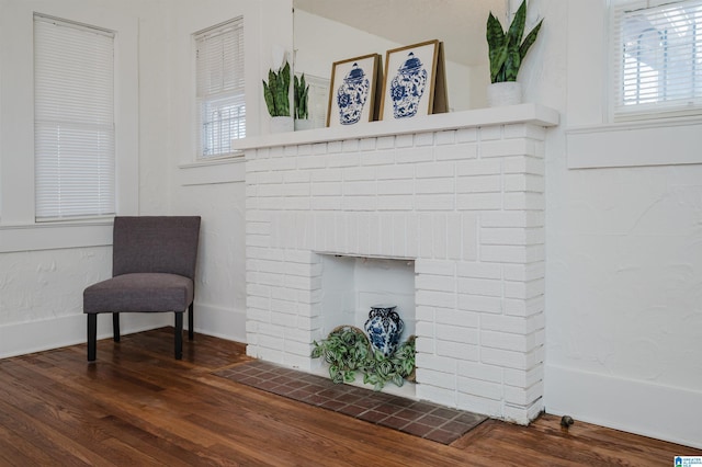 interior space featuring a brick fireplace and wood finished floors