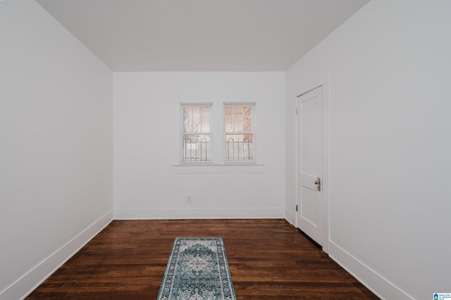 unfurnished room with baseboards and wood finished floors