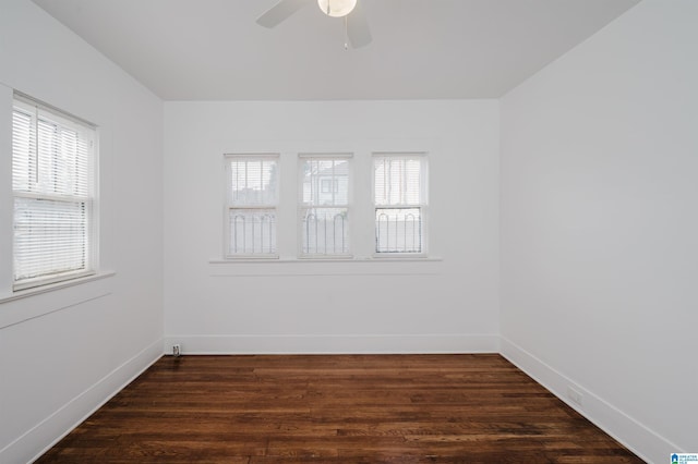 unfurnished room featuring a healthy amount of sunlight, baseboards, and dark wood-style flooring