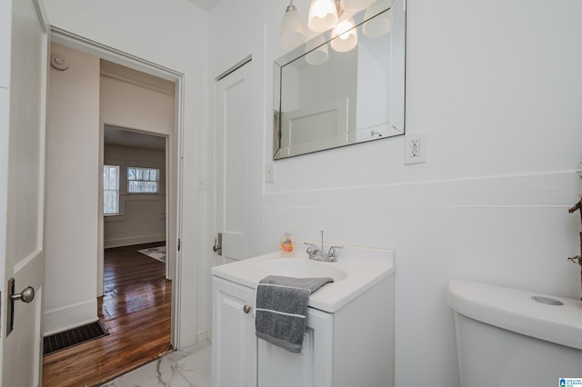 bathroom featuring baseboards, visible vents, toilet, marble finish floor, and vanity