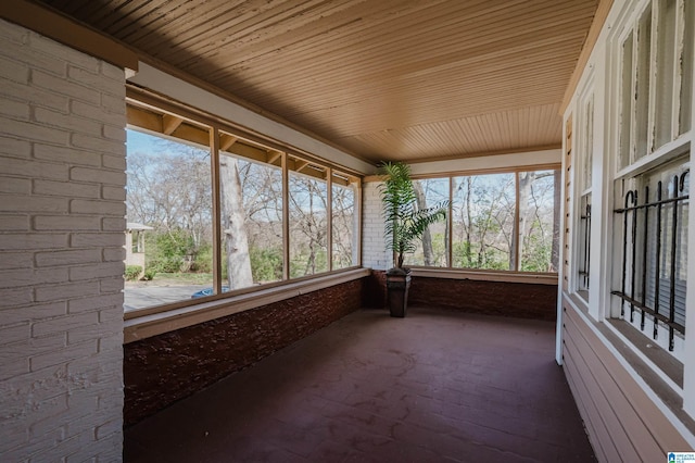 unfurnished sunroom with wooden ceiling and a wealth of natural light