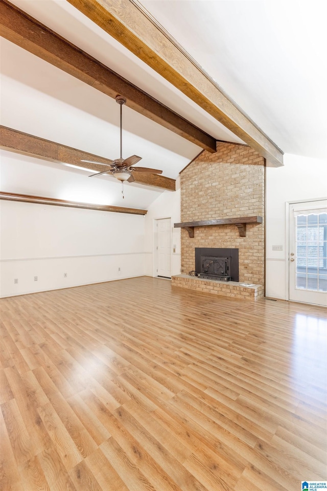 unfurnished living room with vaulted ceiling with beams, light wood-style floors, ceiling fan, and a fireplace