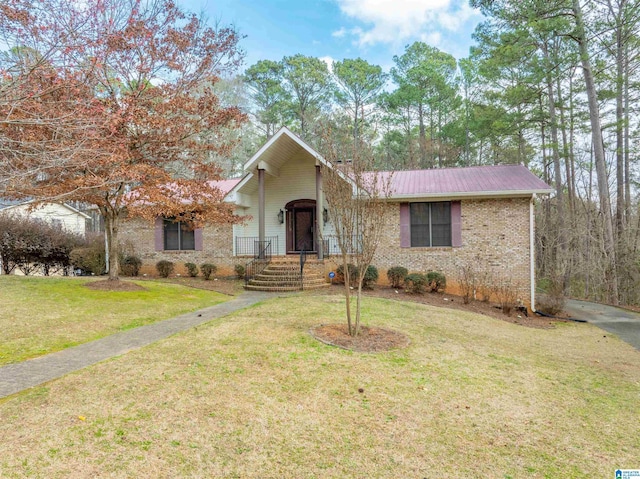 view of front of house featuring a front yard, brick siding, and metal roof