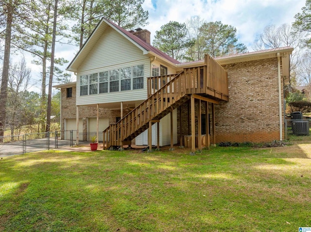 back of property featuring a chimney, stairs, fence, a yard, and brick siding