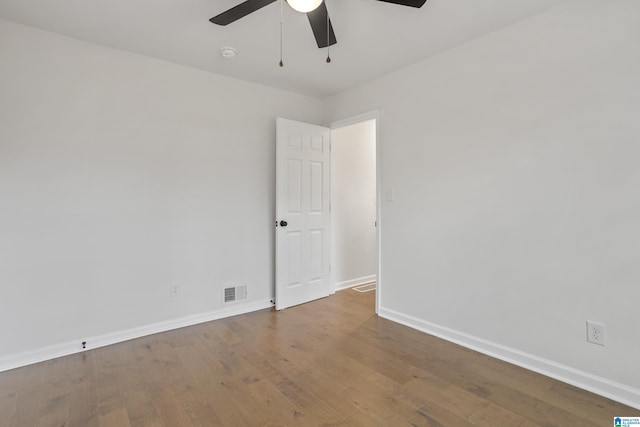 unfurnished room with a ceiling fan, baseboards, visible vents, and hardwood / wood-style floors