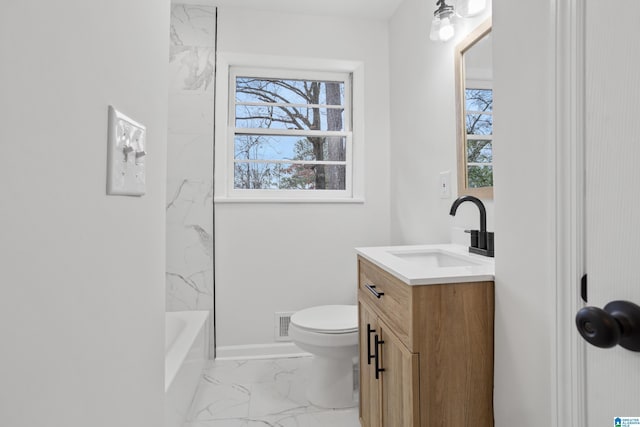 bathroom with marble finish floor, plenty of natural light, vanity, and toilet