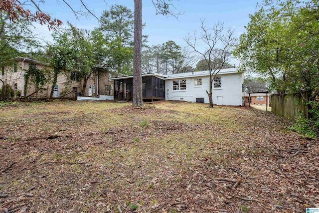 rear view of property with crawl space, fence, and a sunroom