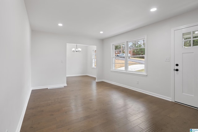 foyer entrance with dark wood-style floors, recessed lighting, baseboards, and an inviting chandelier