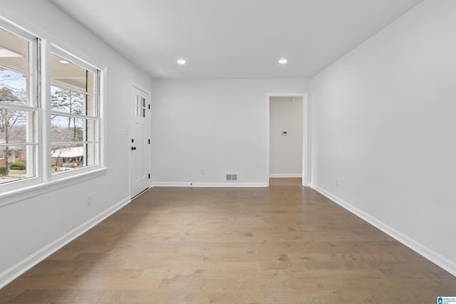 spare room with recessed lighting, visible vents, baseboards, and wood finished floors