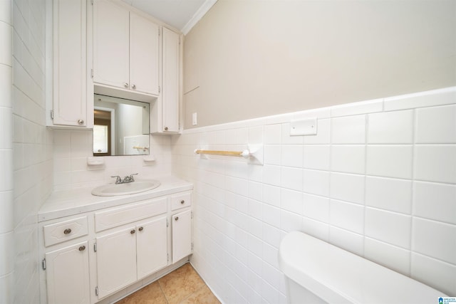 half bath with wainscoting, toilet, tile patterned floors, vanity, and tile walls