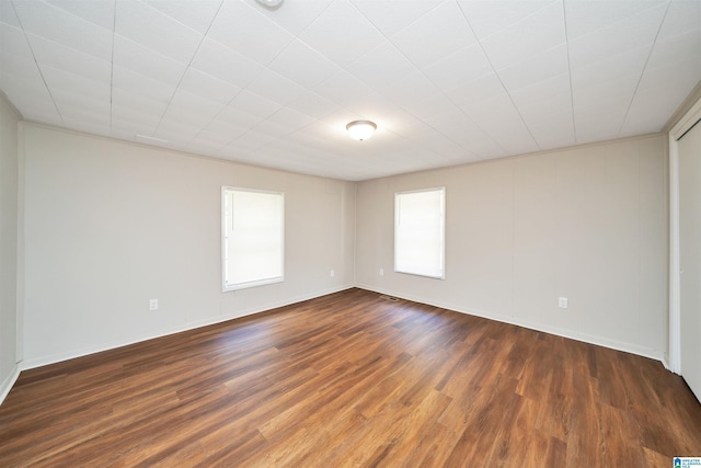 unfurnished room with baseboards and wood finished floors