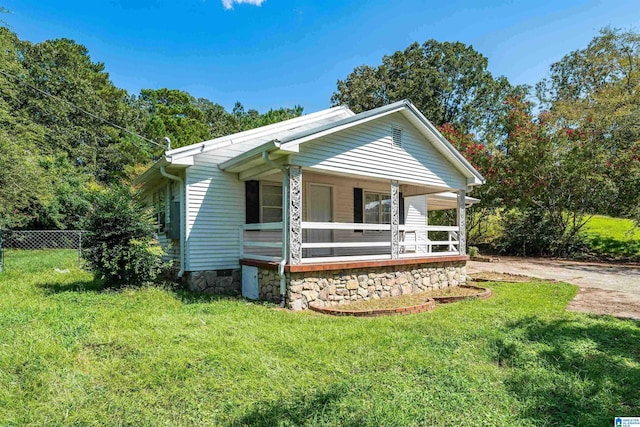 bungalow-style home featuring a front yard, crawl space, covered porch, and fence