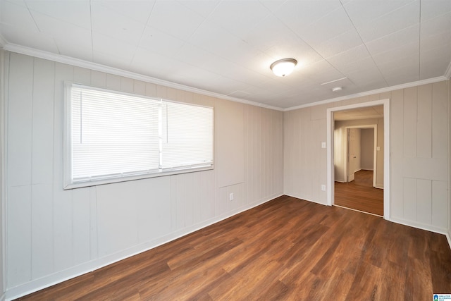 spare room with ornamental molding and dark wood-type flooring