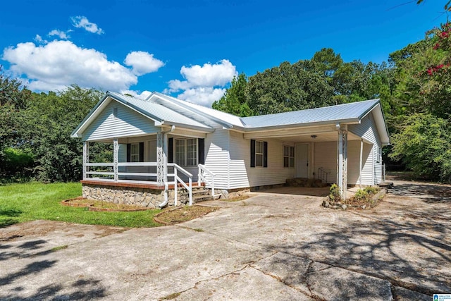 ranch-style house with driveway, metal roof, a porch, and an attached carport