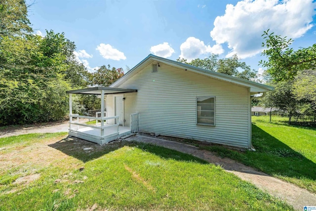 rear view of property featuring a deck and a lawn