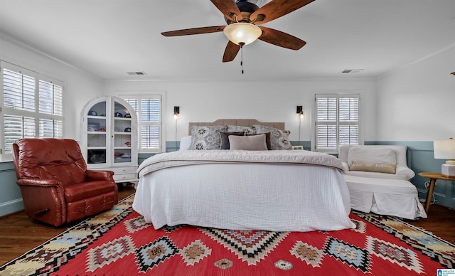 bedroom featuring visible vents, wood finished floors, and crown molding