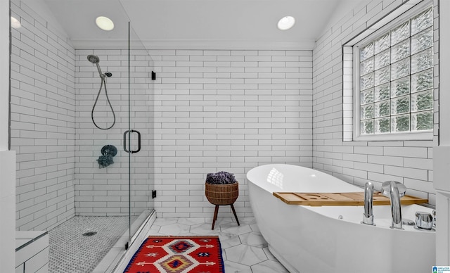 full bath featuring a freestanding tub, tile walls, a shower stall, and crown molding